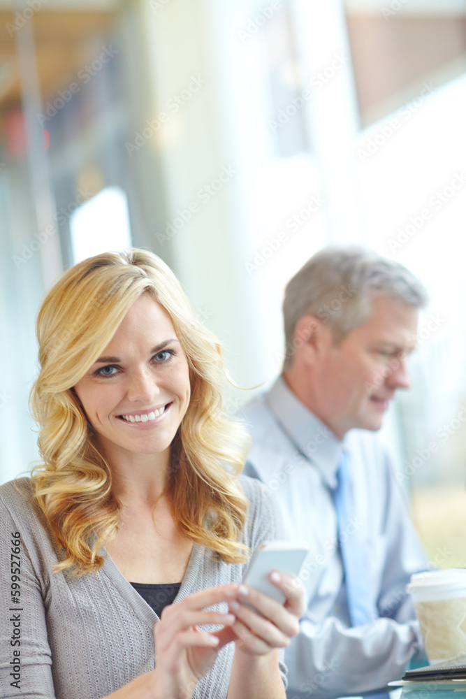 Shes always in touch - Smartphone technology. An attractive businesswoman using her smartphone during a business meeting. Shes always in touch - Smartphone technology. An attractive businesswoman using her smartphone during a business meeting.