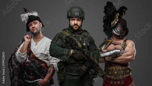 Studio shot of modern soldier with camouflage uniform with aribbean pirate and greek gladiator. © Fxquadro