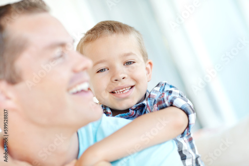 Hi, daddy. a young father and his son relaxing together at home.