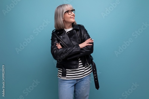 middle age business. 60s mature woman in gray hair looking great in stylish look on blue background © Ivan Traimak