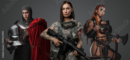 Studio shot of female soldier holding rifle with ancient amazon and knight woman. © Fxquadro