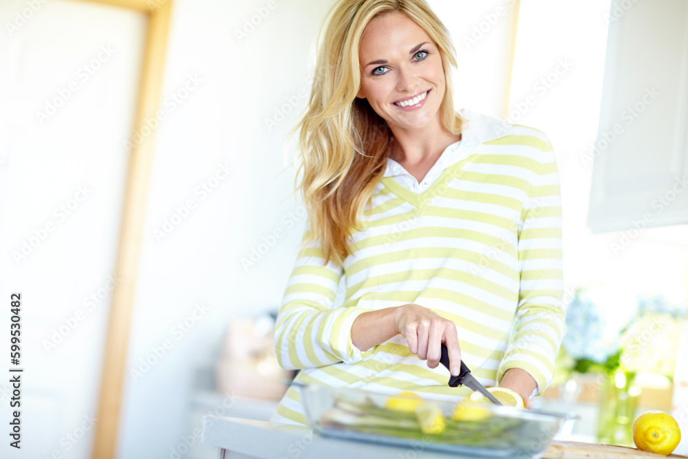 Engaging in some healthy cooking. Attractive young blonde woman slicing lemons in her kitchen at home. Engaging in some healthy cooking. Attractive young blonde woman slicing lemons in her kitchen at home.