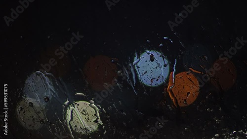 Heavy rain with lightning pours outside the window at night