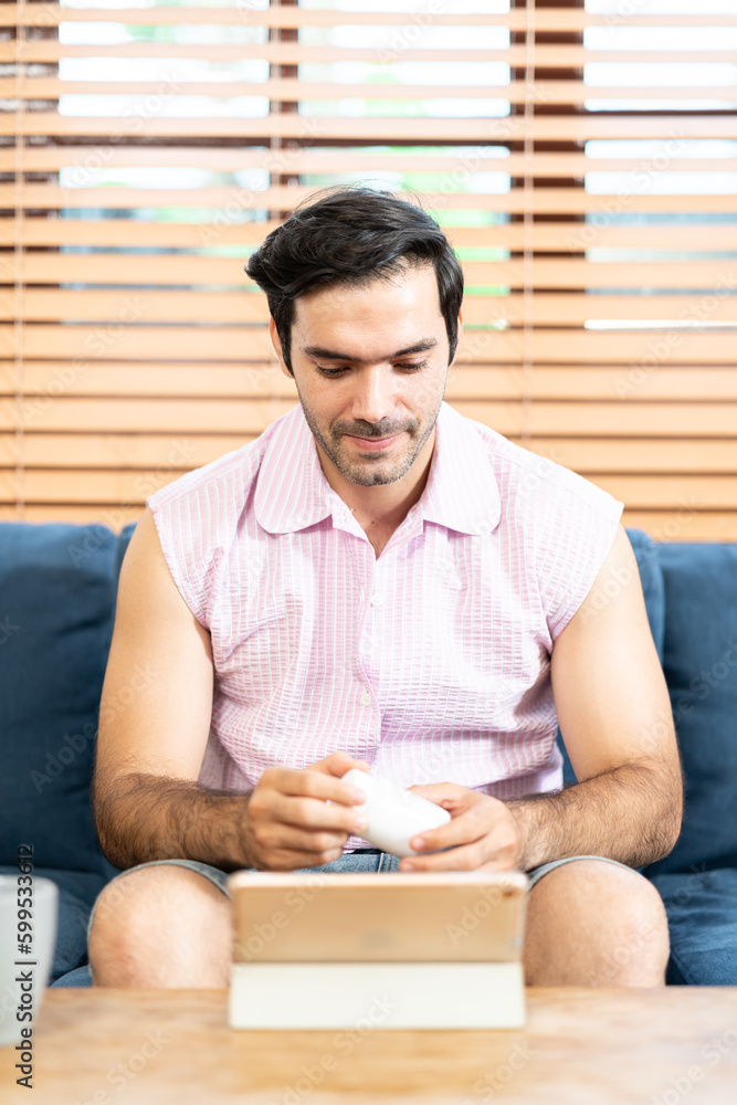 man with medicine bottle using tablet for video calls to ask for medication information. Telemedicine and home health care concept. man with medicine bottle using tablet for video calls to ask for medication information. Telemedicine and home health care concept.