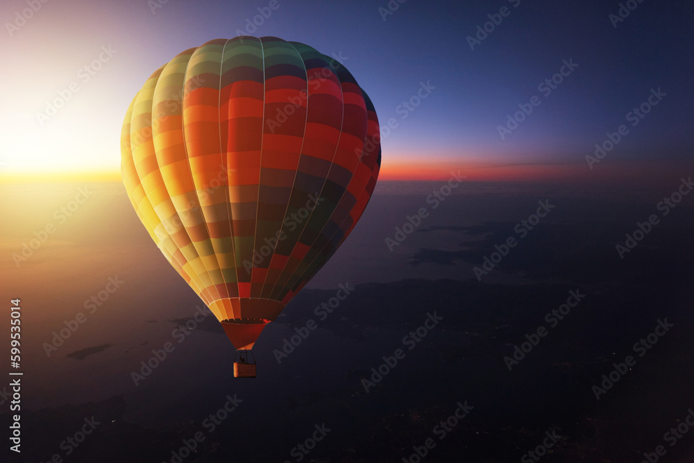 Hot air balloon travel and flies in the evening sky at sunset. Romantic trip on a hot air balloon at dawn