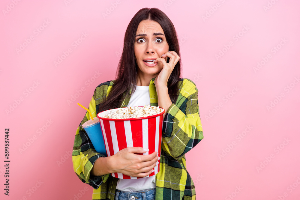 Photo of scared funny lady wear checkered jacket biting fingers watching horror film isolated pink color background Photo of scared funny lady wear checkered jacket biting fingers watching horror film isolated pink color background