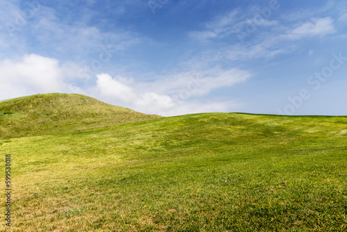 Rolling hills field and a beautiful sky with fluffy clouds