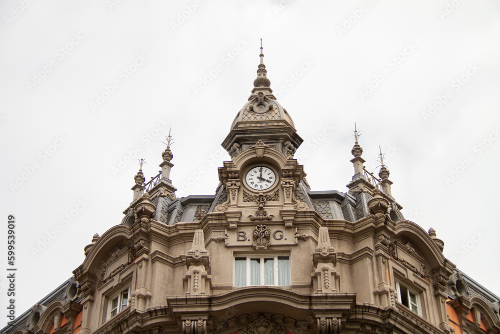 Great gothic cathedral with clock in the city of Gijón de Asturias, with the sky of a cloudy day.