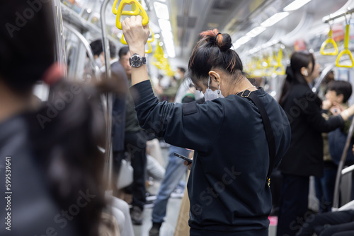 Photography Woman Using Mobilephone inside Crowded Subway Train