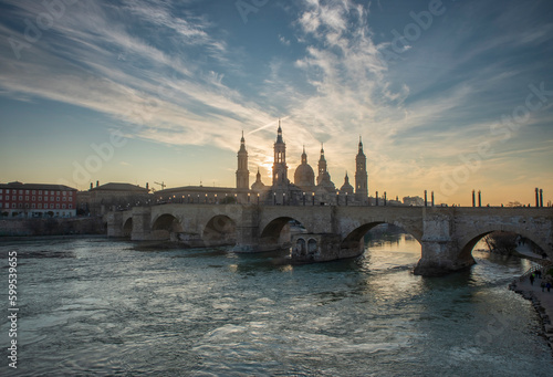 del Pilar basilica, one of the important architectural symbols of zaragoza, and the Ebro river and its reflection with sunset colors and clouds