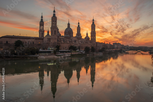 del Pilar basilica, one of the important architectural symbols of zaragoza, and the Ebro river and its reflection with sunset colors and clouds