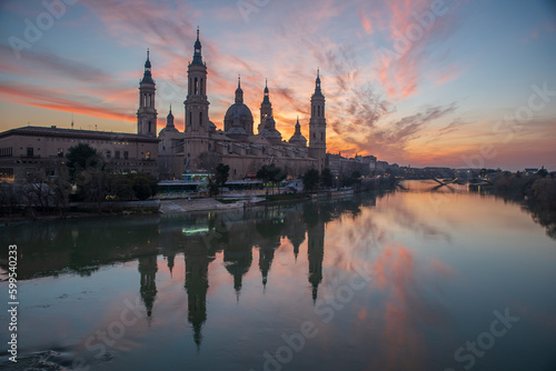 del Pilar basilica  one of the important architectural symbols of zaragoza  and the Ebro river and its reflection with sunset colors and clouds