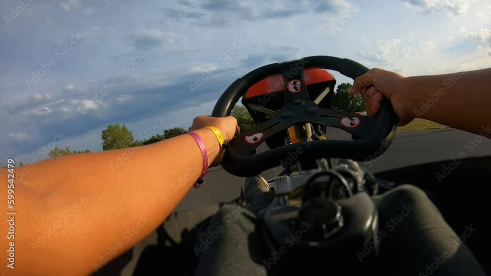Man is driving a go-cart on the race track outdoors