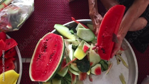 pensioner woman hands cutting fresh watermelon
