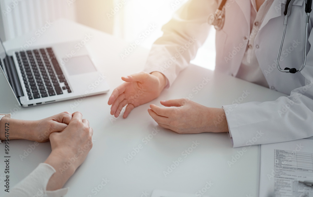 Doctor and patient discussing current health questions while sitting at the table in clinic office, only hands closeup. Medicine concept Doctor and patient discussing current health questions while sitting at the table in clinic office, only hands closeup. Medicine concept