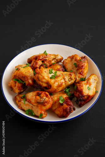 Homemade Grilled Chicken Wings with Parsley on a Plate, side view.