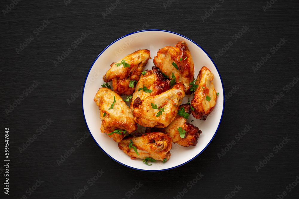 Homemade Grilled Chicken Wings with Parsley on a Plate, top view. Close-up. Homemade Grilled Chicken Wings with Parsley on a Plate, top view. Close-up.