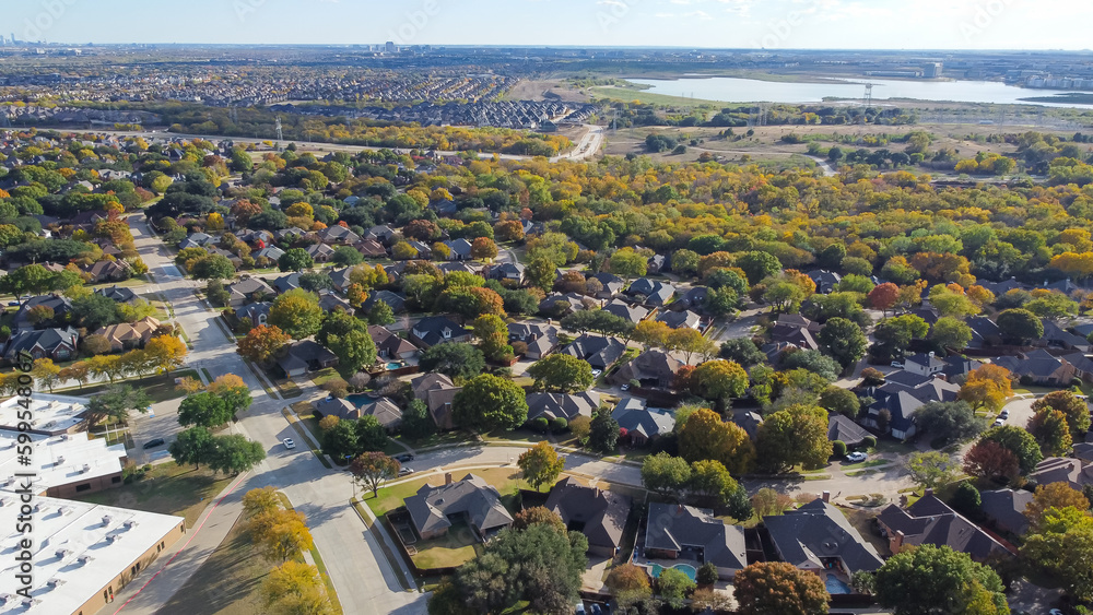 Lakeside master planned community urban sprawl mixed of single-family homes and apartment complex, downtown building distance background colorful fall leaves in North Texas, USA