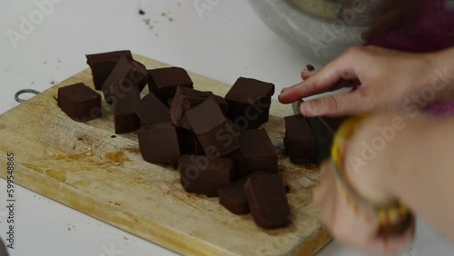 close up female hands cutting chocolate 