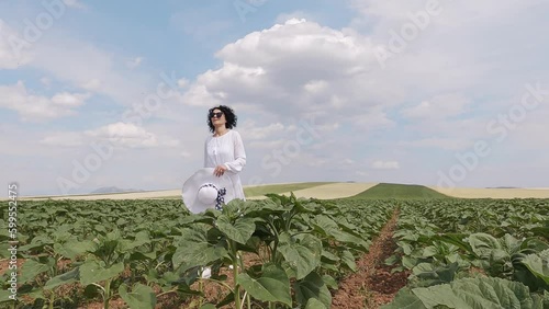 Wallpaper Mural Positive farmer woman with hat walking in beans agriculture field at sunny day, slow motion Torontodigital.ca