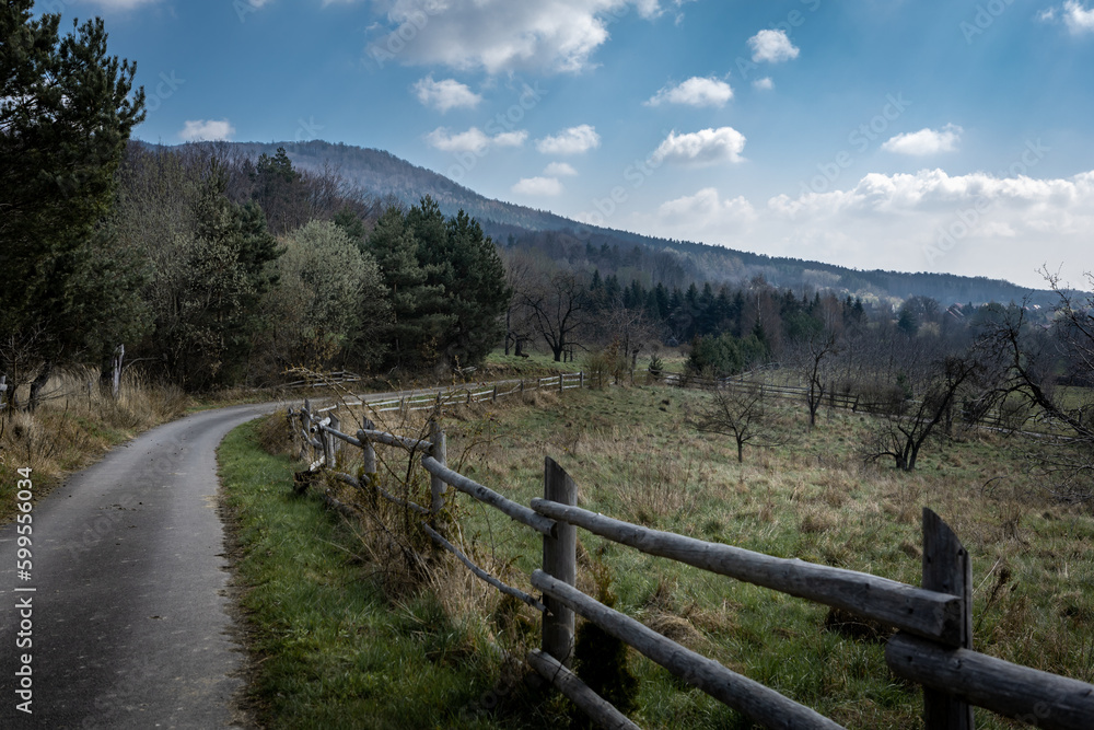 A path along with old wooden fence in the countryside  in the springtime. Sleza Massif, Poland. 
