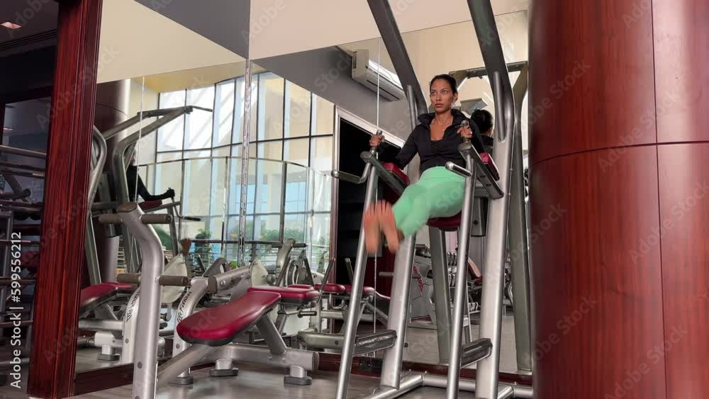 Hand-held shot of a young female working on her core muscles in a gym Hand-held shot of a young female working on her core muscles in a gym