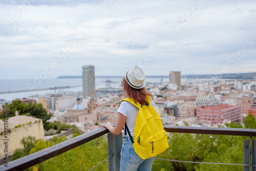 Happy traveler girl sightsees and tours the city of Alicante Spain.