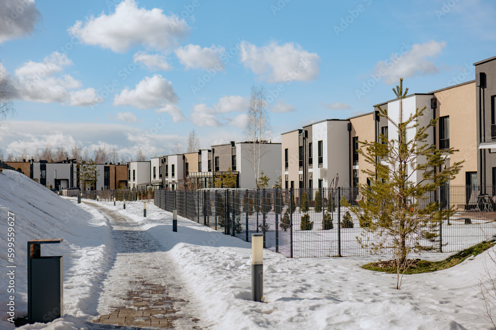 Residential town house buildings in winter. Modern town houses. Footpath along modern houses and nature Residential town house buildings in winter. Modern town houses. Footpath along modern houses and nature