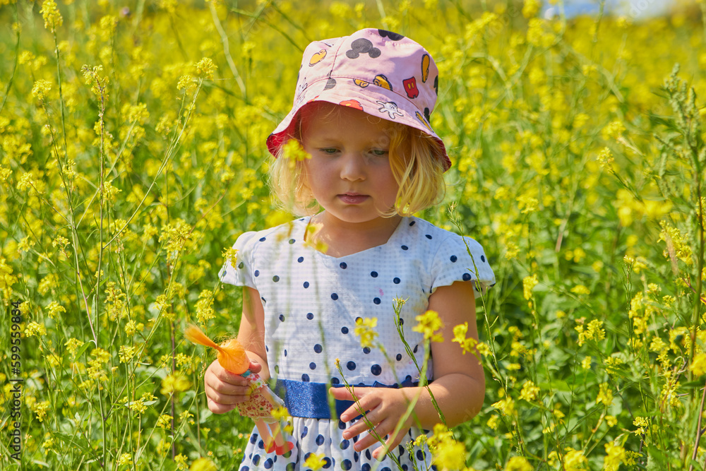 a little girl in a rape field,the child walks in yellow flowers in the field a little girl in a rape field,the child walks in yellow flowers in the field