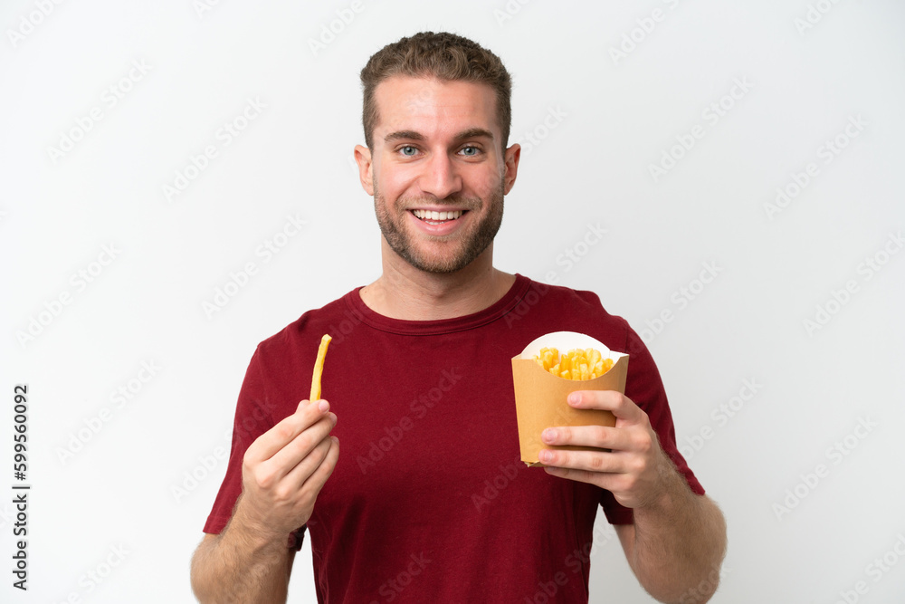 Young caucasian man holding fries potatoes isolated on white background Young caucasian man holding fries potatoes isolated on white background