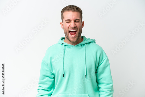 Young handsome caucasian man isolated on white background shouting to the front with mouth wide open © luismolinero
