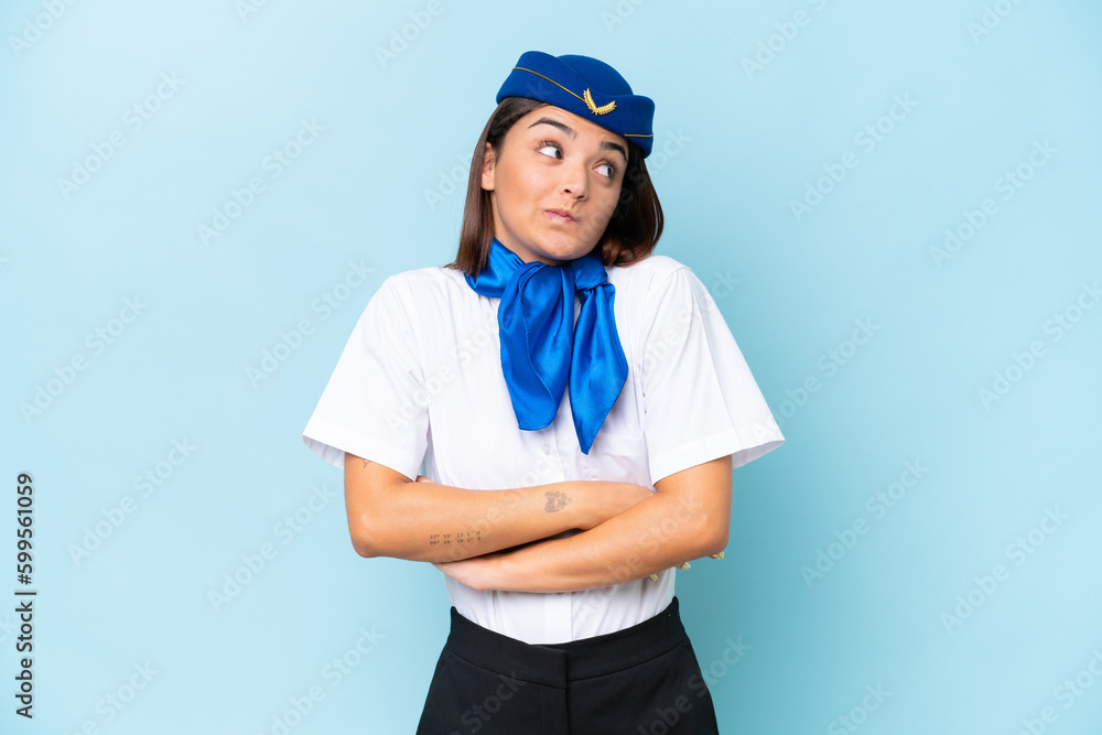 Airplane stewardess caucasian woman isolated on blue background making doubts gesture while lifting the shoulders Airplane stewardess caucasian woman isolated on blue background making doubts gesture while lifting the shoulders