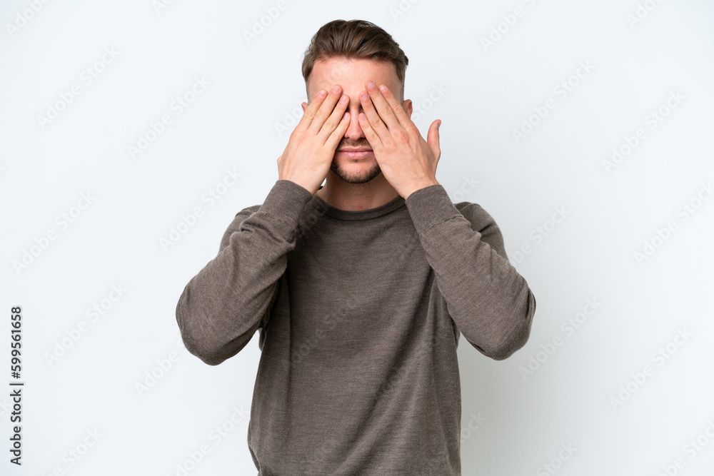 Young blonde caucasian man isolated on white background covering eyes by hands Young blonde caucasian man isolated on white background covering eyes by hands