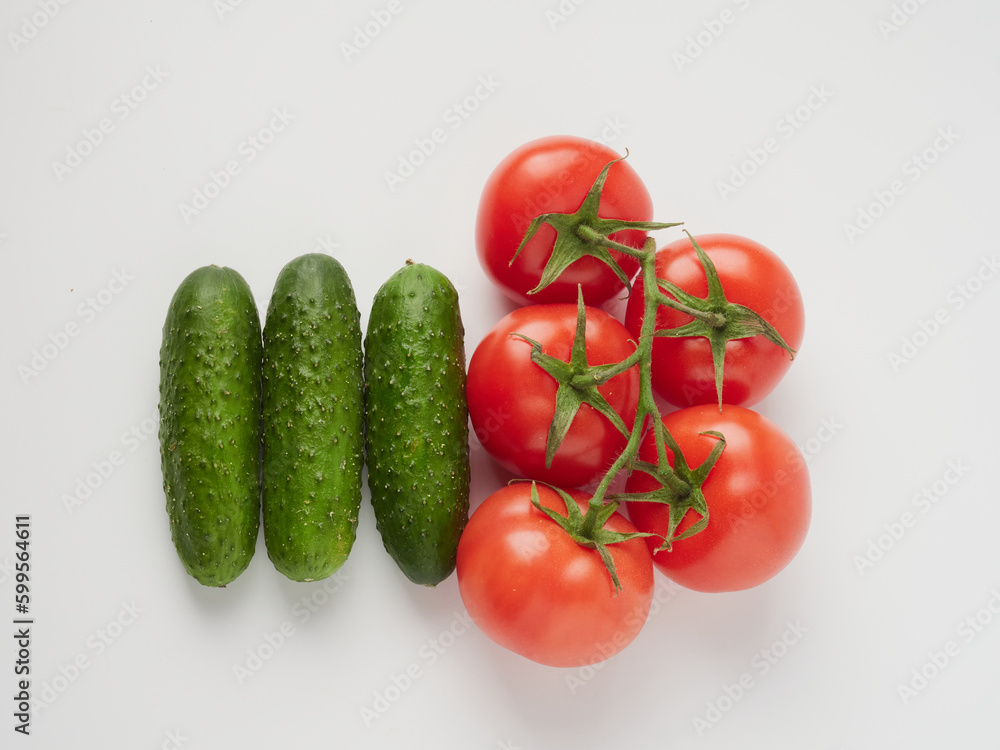 Cucumber and tomato close-up on a white isolated background. Natural ripe vegetables, organic tomato and cucumber top view Cucumber and tomato close-up on a white isolated background. Natural ripe vegetables, organic tomato and cucumber top view