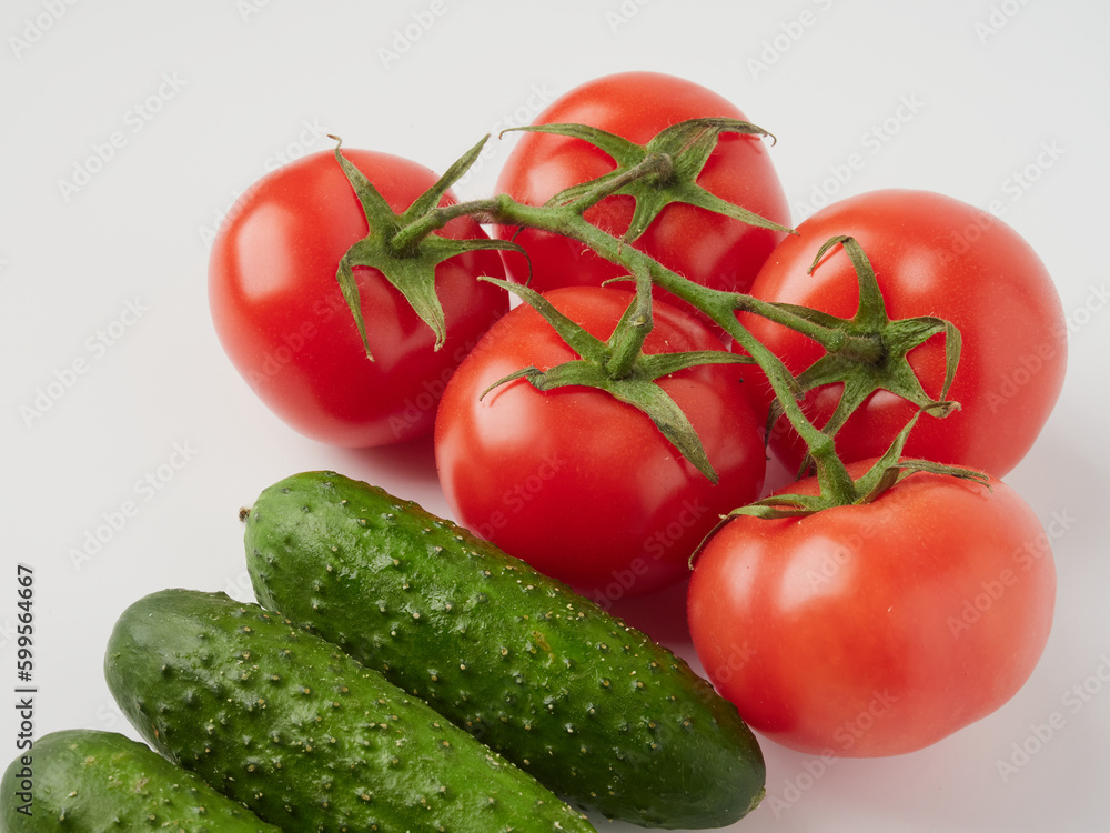 Cucumber and tomato close-up on a white isolated background. Natural ripe vegetables, organic tomato and cucumber top view Cucumber and tomato close-up on a white isolated background. Natural ripe vegetables, organic tomato and cucumber top view