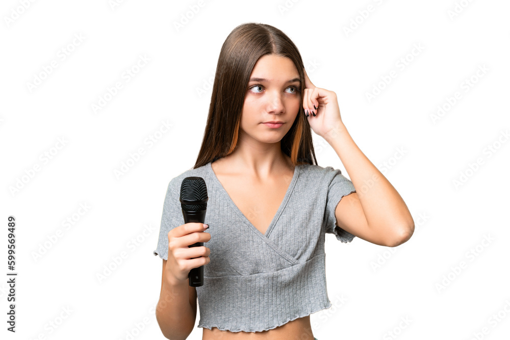 Teenager singer girl picking up a microphone over isolated background having doubts and thinking Teenager singer girl picking up a microphone over isolated background having doubts and thinking