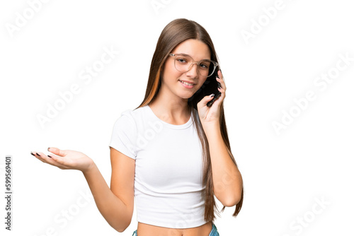 Teenager caucasian girl over isolated background keeping a conversation with the mobile phone with someone © luismolinero