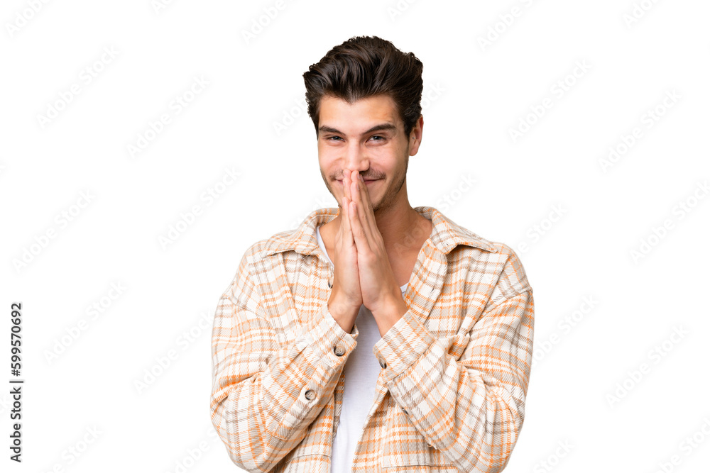 Young handsome caucasian man over isolated background keeps palm together. Person asks for something Young handsome caucasian man over isolated background keeps palm together. Person asks for something