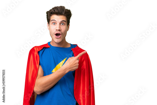 Super Hero caucasian man over isolated background surprised and pointing side