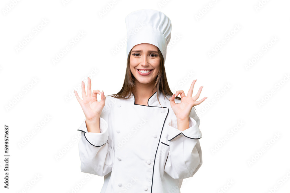 Young chef caucasian woman over isolated background showing an ok sign with fingers