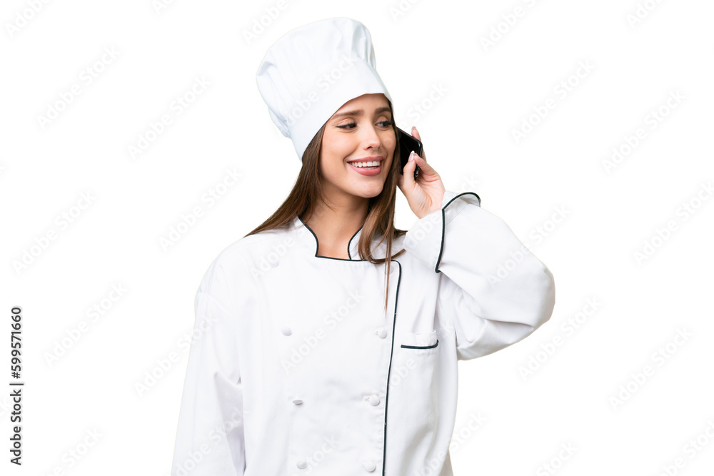 Young chef caucasian woman over isolated background keeping a conversation with the mobile phone Young chef caucasian woman over isolated background keeping a conversation with the mobile phone