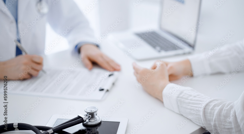 Stethoscope lying on the tablet computer in front of a doctor and patient sitting opposite each other at the background . Medicine, healthcare concept Stethoscope lying on the tablet computer in front of a doctor and patient sitting opposite each other at the background . Medicine, healthcare concept