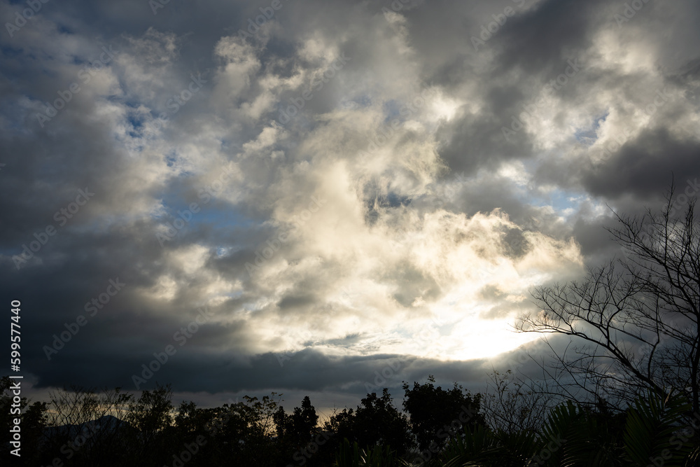 silhouette of the sun on a dark rainy sky; a sunshine after the rain silhouette of the sun on a dark rainy sky; a sunshine after the rain