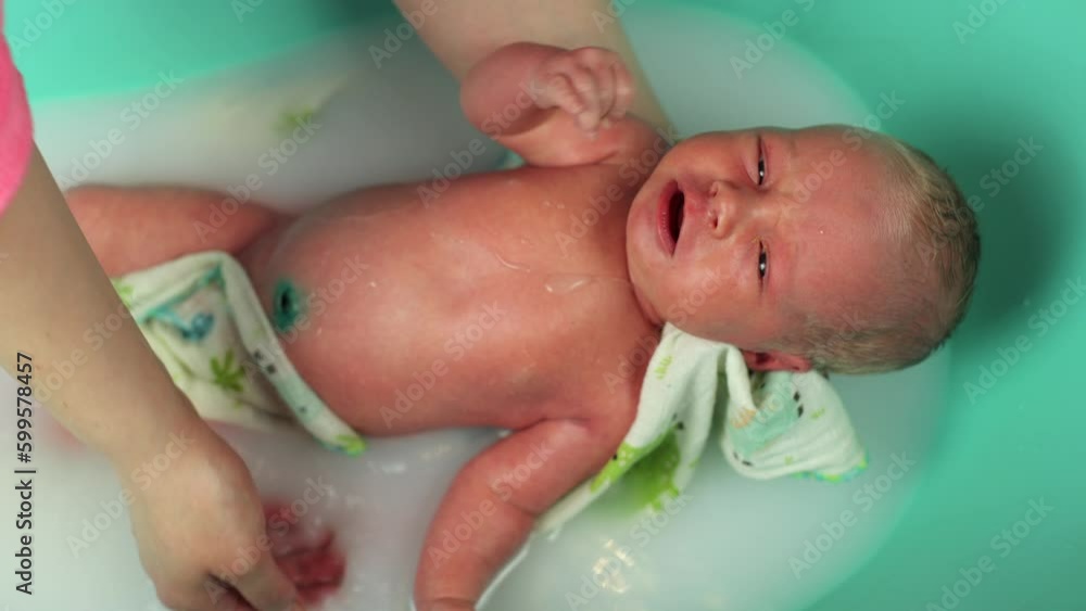 A newborn baby. Newborn baby boy swimming in water. The first days of a two-week-old baby's life. A child with white hair. Joy for parents, a newborn boy. Children's procedures. Small bathroom A newborn baby. Newborn baby boy swimming in water. The first days of a two-week-old baby's life. A child with white hair. Joy for parents, a newborn boy. Children's procedures. Small bathroom