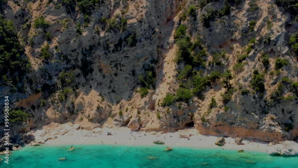 Cala Mariolu Beach Sardinia Italy, a beautiful beach full of beach umbrellas and people sunbathing and swimming in turquoise water. Cala Gonone Baunei, Sardinia, Italy Golfo Di Orosei Cala Mariolu Beach Sardinia Italy, a beautiful beach full of beach umbrellas and people sunbathing and swimming in turquoise water. Cala Gonone Baunei, Sardinia, Italy Golfo Di Orosei