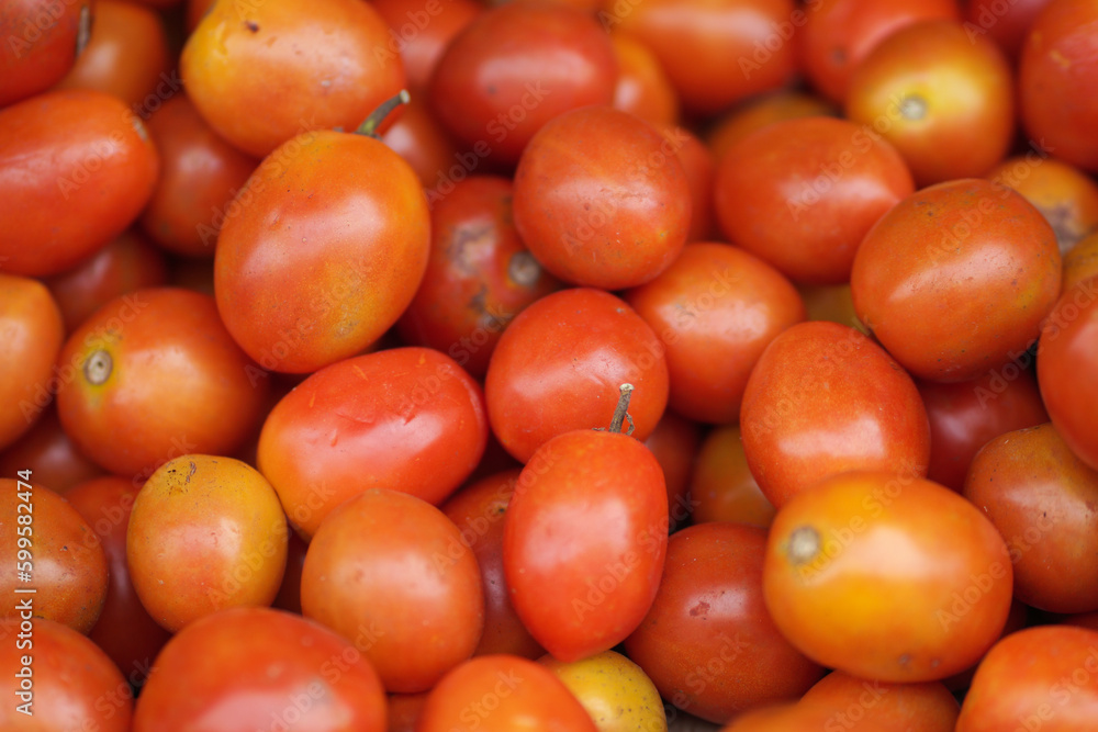 Tomatoes lying on a pile on top of each other, tomato texture. Selective focus.