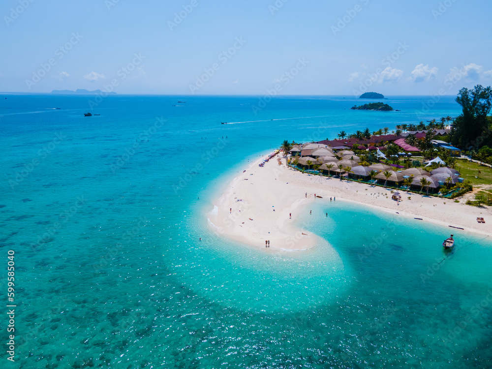 Obraz premium men and women walking on a sandbar in the ocean of Koh lipe Southern Thailand during vacation