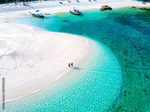 men and women walking on a sandbar in the ocean of Koh lipe Southern Thailand during vacation