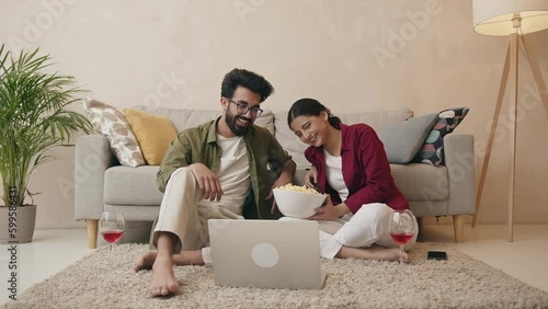 Happy couple enjoying the movie on the laptop and spending day together