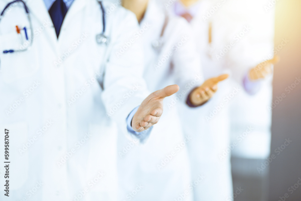 Unknown doctors, two men and a woman, discuss medical exam resoults, while standing at sunny hospital office. Physicians using clipboards for filling up medication history records Unknown doctors, two men and a woman, discuss medical exam resoults, while standing at sunny hospital office. Physicians using clipboards for filling up medication history records